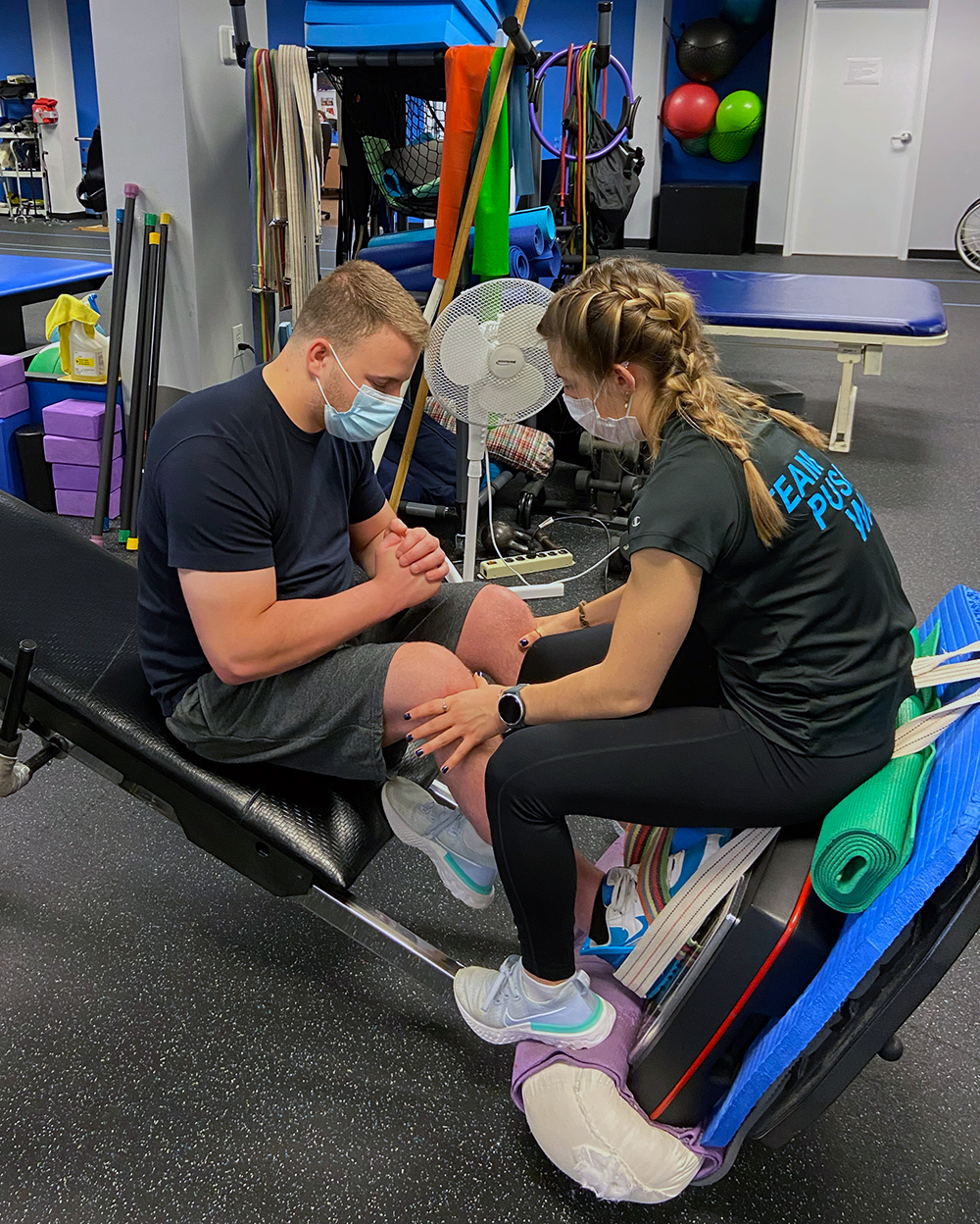 A trainer works with a client's legs in the Push to Walk gym