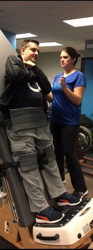 tiffany A Push to Walk client stands with the help of specialized equipment and his trainer